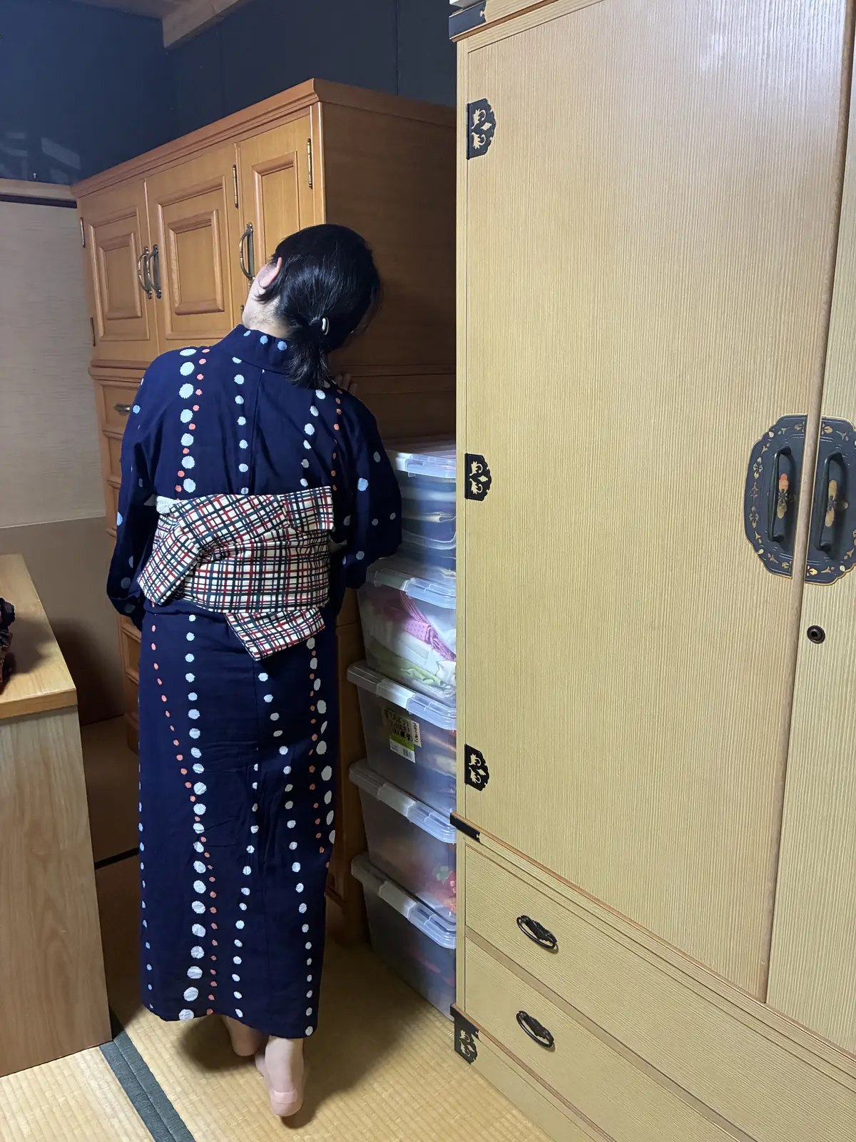 着物小屋で和箪笥を見上げている後ろ姿